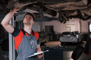 need an mot, garage technician inspecting vehicle
