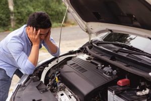 basic car problems, man looking stressed next to car