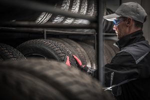 Mechanic comparing all-season vs run-flat tyres.