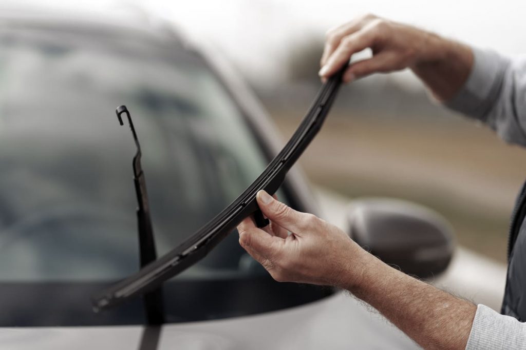 A technician installing aero wiper blades.