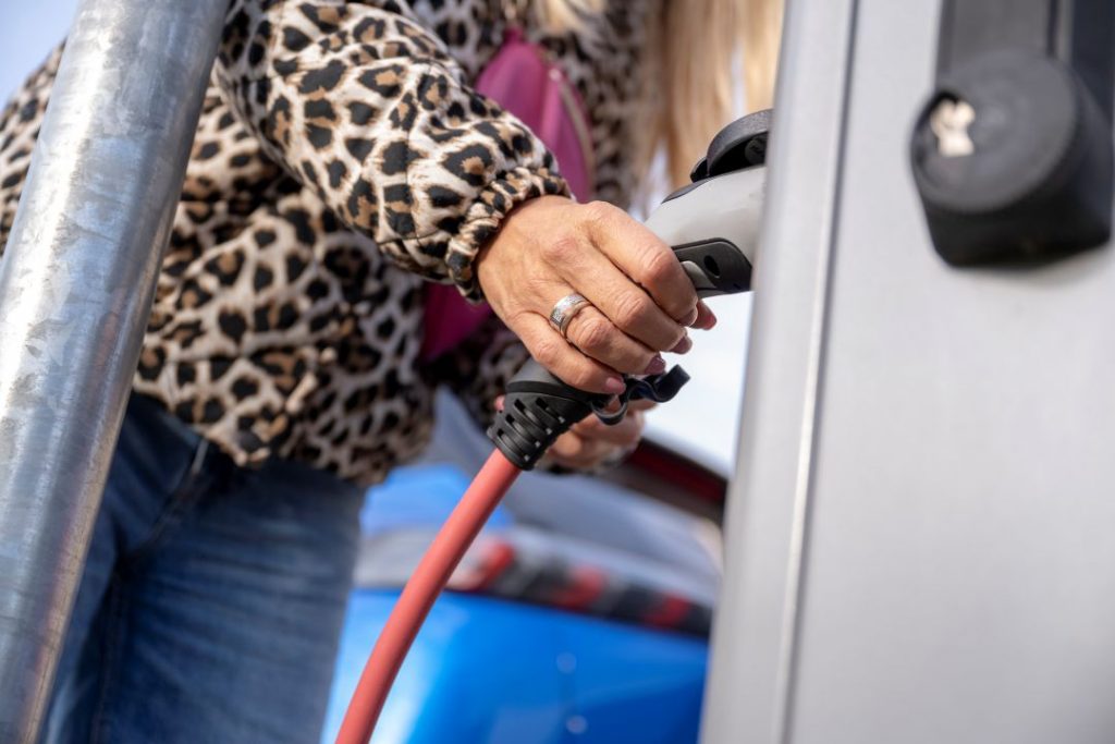 EV mileage tax, a person charing their electric vehicle