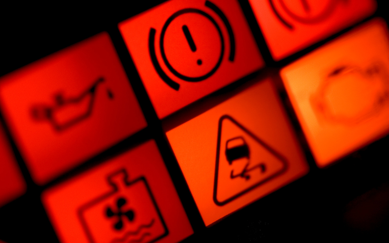 Close-up of illuminated dashboard warning lights in a car instrument cluster