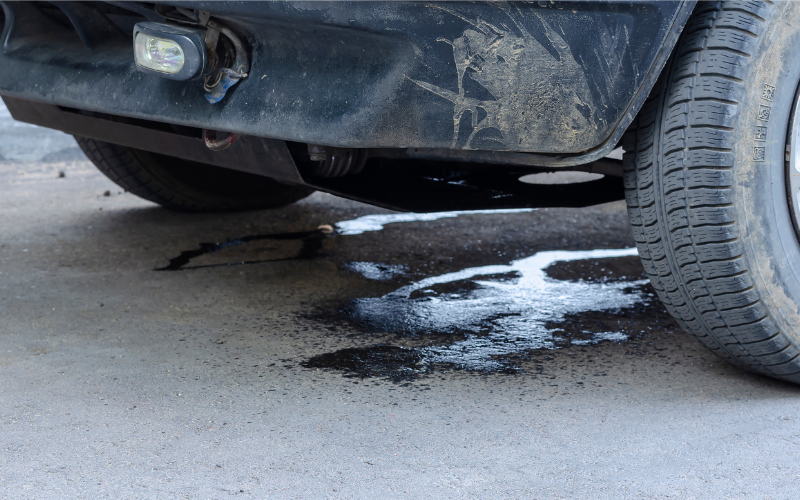 Fluid leaking underneath a car parked on a driveway