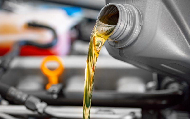 Fresh engine oil being poured into a vehicle engine