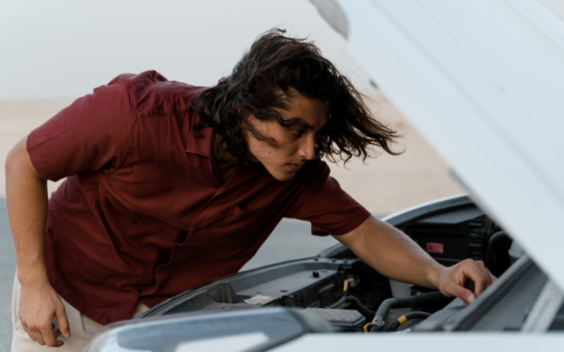 Driver checking fluid levels and engine components before an MOT test