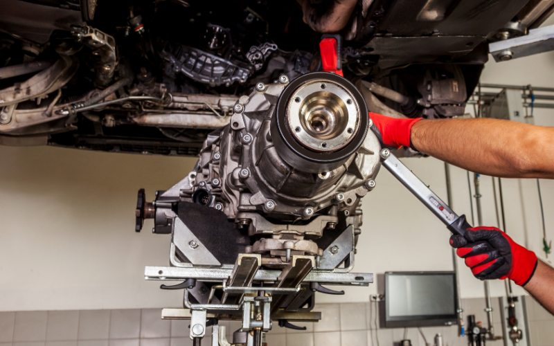 Mechanic working on a car gearbox during a clutch repair